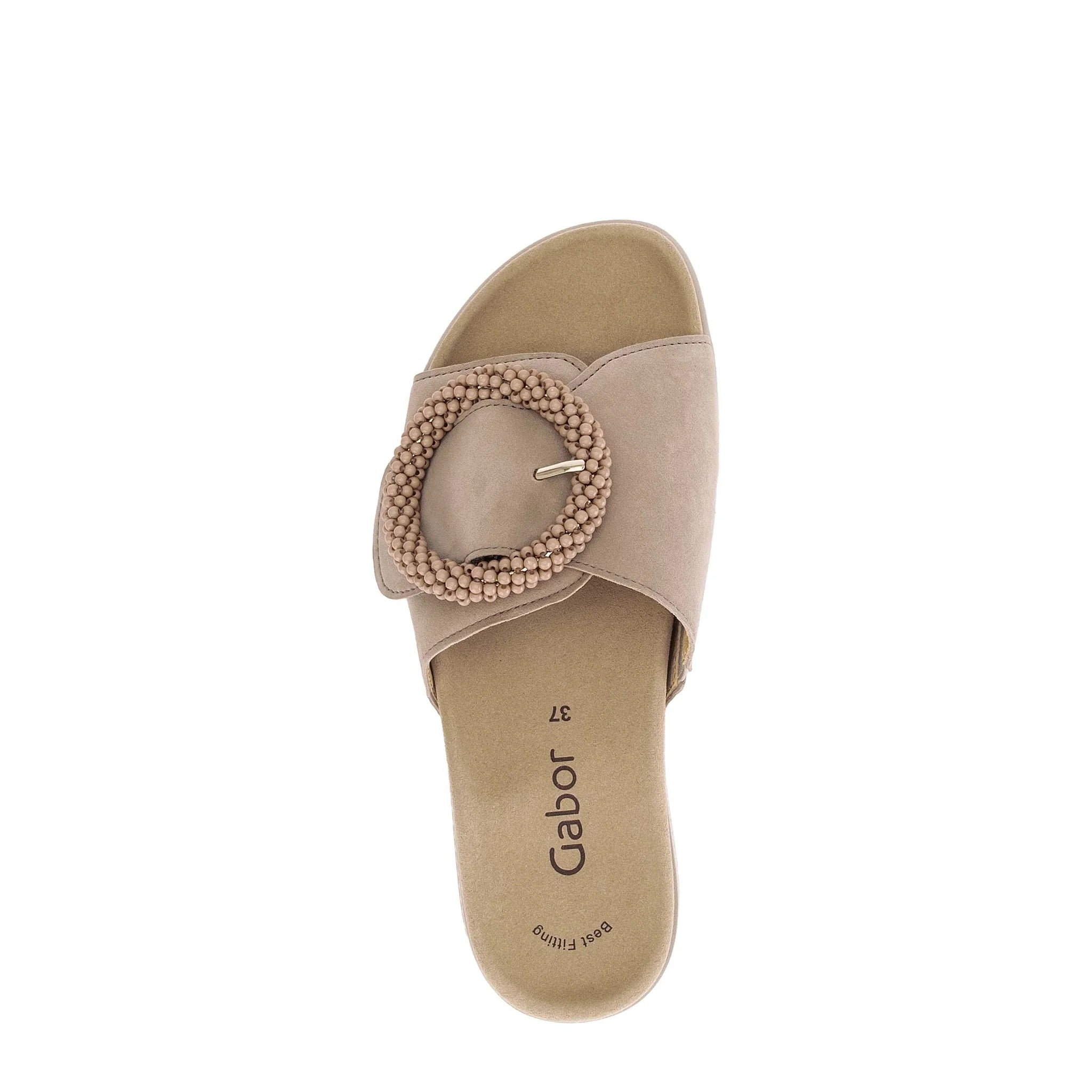 Beige sandal with a decorative buckle on a white background