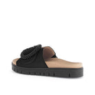 Black sandal with decorative element on a white background