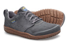 A pair of low-top shoes in dark gray suede and mesh, featuring brown rubber soles and a small blue and yellow logo accent on the side and tongue.