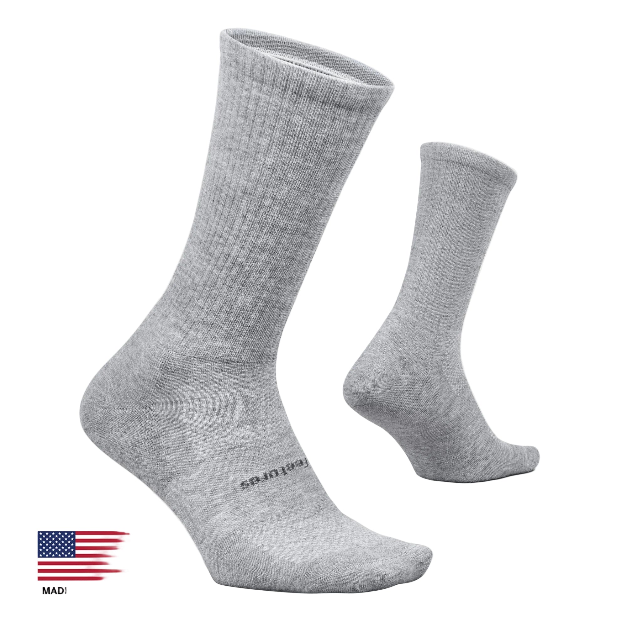 A pair of light gray heather crew socks shown on a clean off-white background, with one sock standing upright and the other lying on its side. A small 'Made in the USA' flag graphic appears in the bottom-left corner.