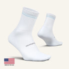 White socks with a brand logo on a light beige background, featuring 'Made in the USA' text.