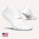 Two white socks with a brand logo on a light gray background, featuring 'Made in the USA' text.