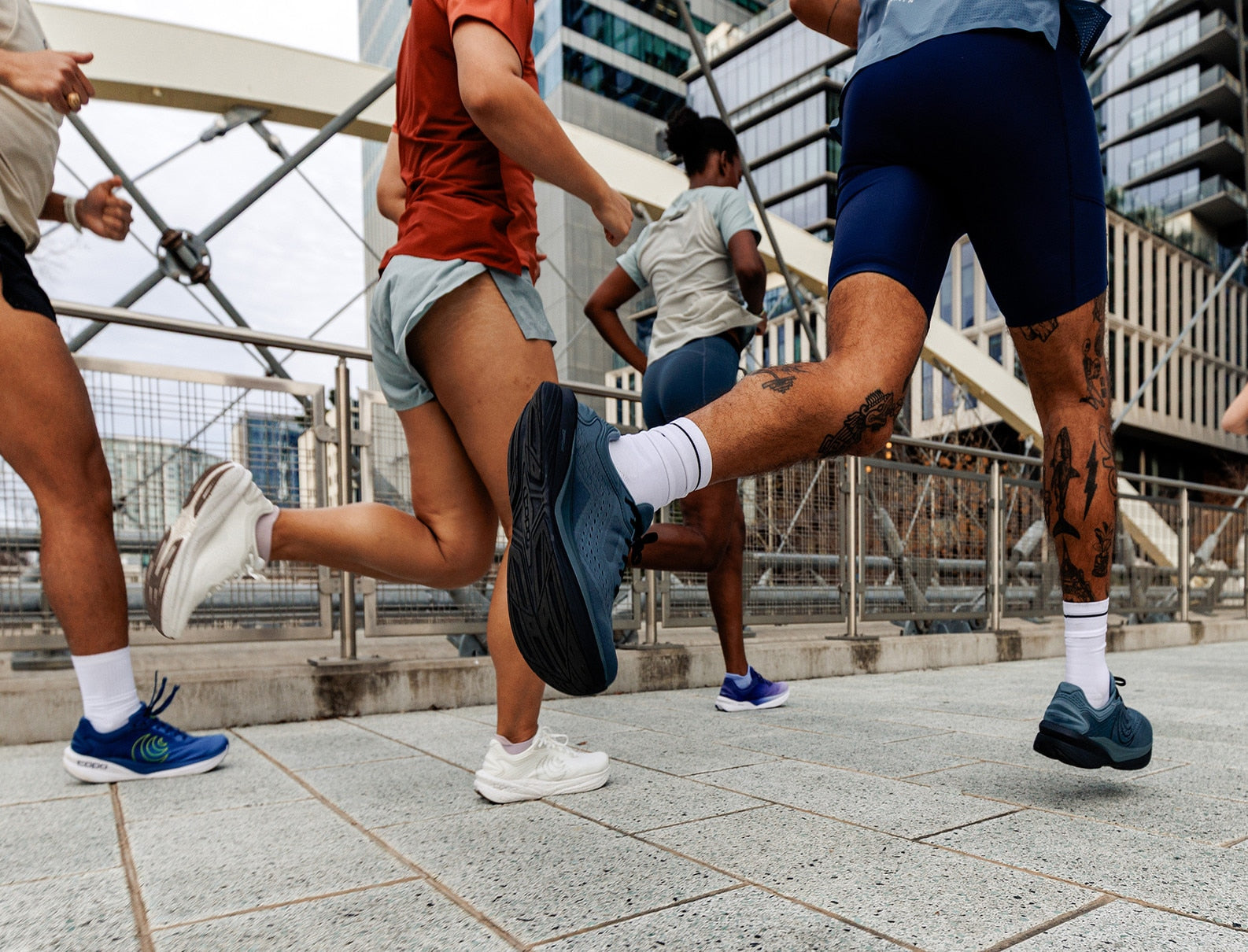 People running on a city street with buildings in the background