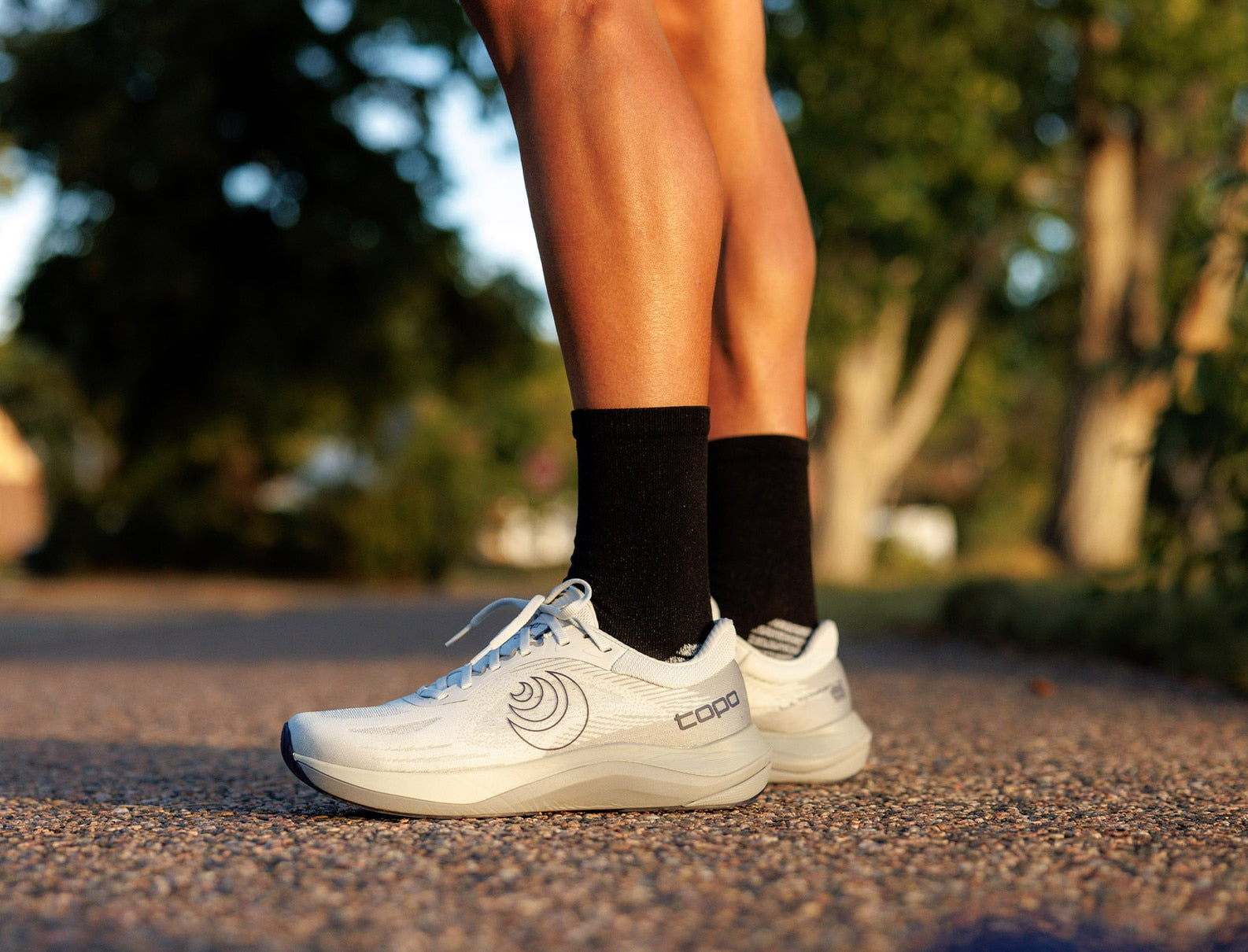 White running shoes with a brand logo on a blurred outdoor background