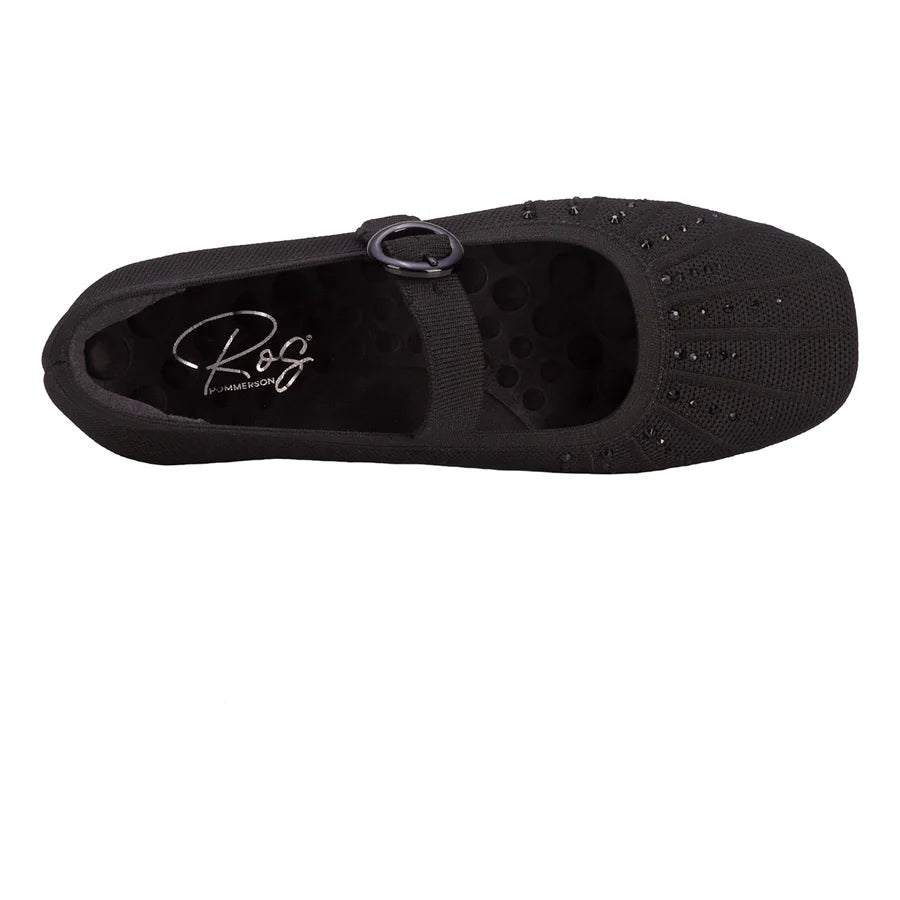 Black ballet flat shoe with a strap on a white background