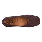 Brown flat shoe with textured sole on a white background