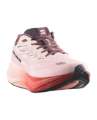 Salomon running shoe in light pink and coral red with dark purple accents, shown from a three-quarters angle on a white background.