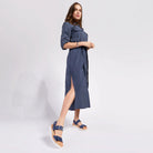 Woman wearing a blue dress with a slit on a white background