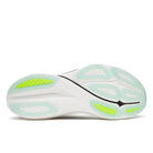 Close-up of a running shoe sole with green accents on a white background