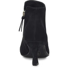 Black suede ankle boot with a kitten heel and side zipper, shown from a rear three-quarter angle on a white background.