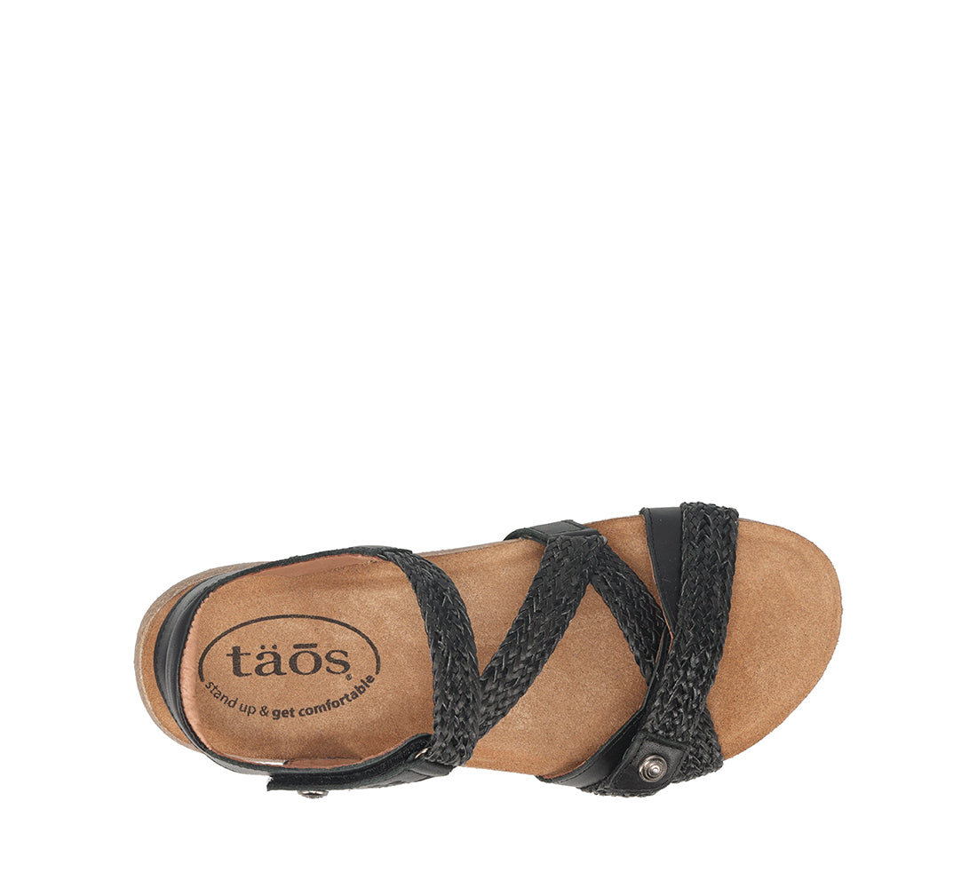 Tan sandal with black straps on a white background