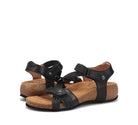Pair of black sandals with cork soles on a white background