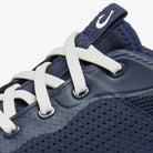Navy blue sneaker with white laces on a white background