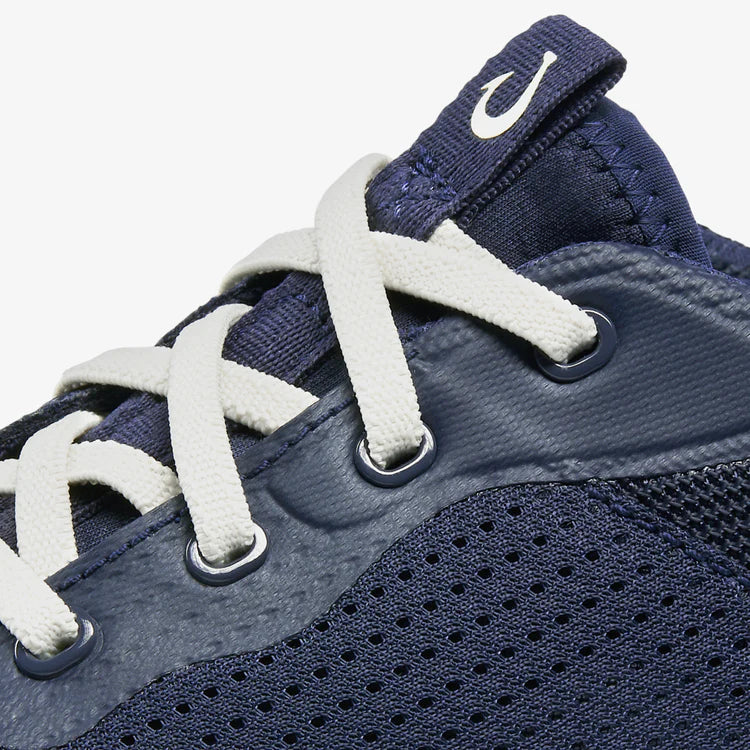 Navy blue sneaker with white laces on a white background
