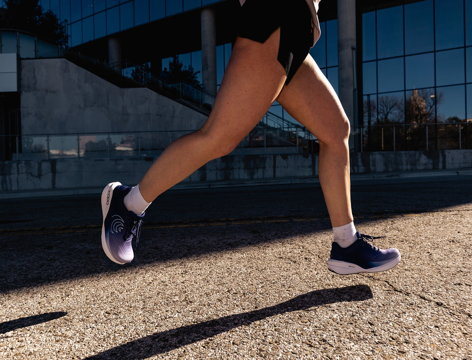 Person running on a road with a building in the background