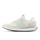 Beige sneaker with a light blue accent on a white background