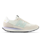 Beige sneaker with a light blue accent on a white background