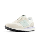 Beige sneaker with a light blue accent on a white background