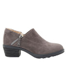 A single women's ankle boot in taupe-brown suede, featuring a low block heel, a side zipper with a silver pull tab, and a black sole, shown against a plain white background.