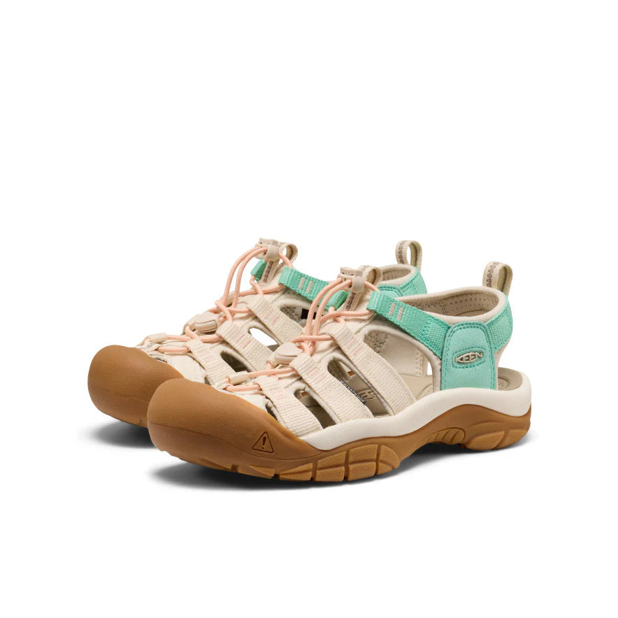 Pair of Keen sandals with brown soles and green uppers on a white background