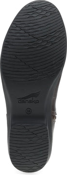 A close-up view of the black rubber outsole of a boot, showing the tread pattern and the 'dansk' brand logo printed in the center.