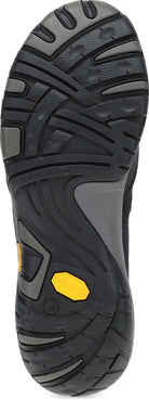 Close-up of the outsole of a hiking shoe, showing a black Vibram tread with a small yellow accent near the heel.