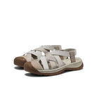 Pair of beige sandals with brown soles on a white background