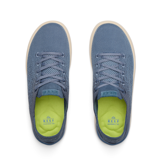 Blue sneakers with green soles on a white background