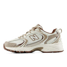 A New Balance athletic sneaker in beige, cream, and brown, shown from a side profile view against a plain white background.