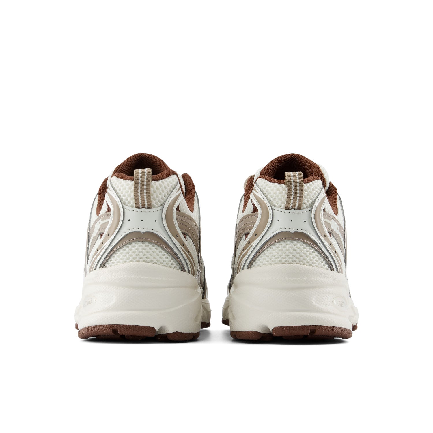 A pair of low-top athletic sneakers shown from the back, featuring a cream and beige mesh upper with brown accents on the collar, lining, and outsole.