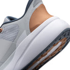 Close-up of a gray and white sneaker with brown accents on a white background