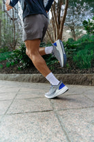 Person running on a paved path with greenery in the background