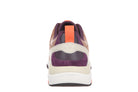 A rear view of a low-top sneaker featuring a purple suede heel counter, a cream leather V-cut overlay, an orange pull tab, and a white midsole on a white background.