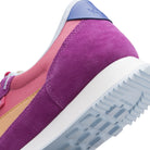 Close-up of a purple and pink sneaker with a white sole on a white background
