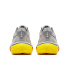 Gray athletic shoes with yellow soles on a white background