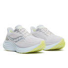 White running shoes with yellow soles on a white background
