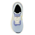 A single New Balance running shoe shown from a top-down view, featuring a light blue and lavender upper with white laces and a black interior lining.