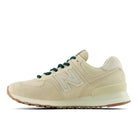 Beige sneaker with green laces on a white background