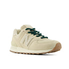 Beige sneaker with green laces on a white background