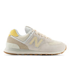 Beige sneaker with yellow accents on a white background