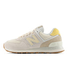 Beige sneaker with yellow accents on a white background