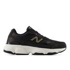 Black athletic shoe with white sole on a light gray background