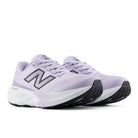 Pair of purple running shoes with New Balance logo on a white background